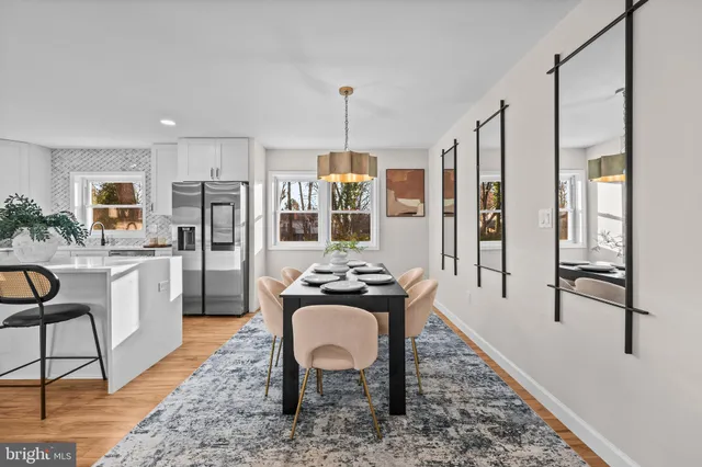 a dining room with wooden floor a chandelier a wooden table and chairs