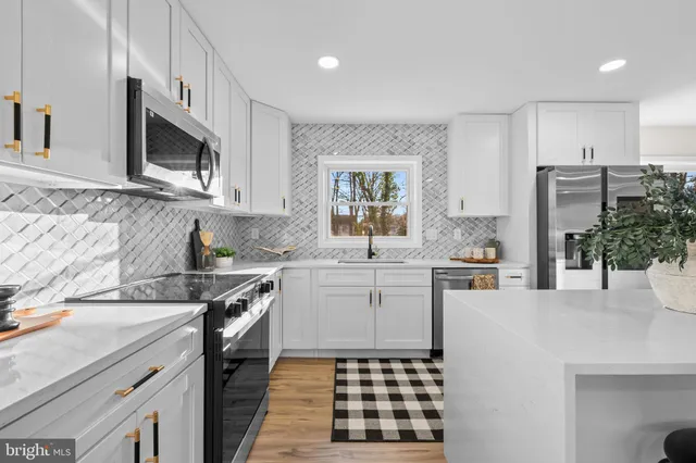 a kitchen with stainless steel appliances a sink stove and microwave