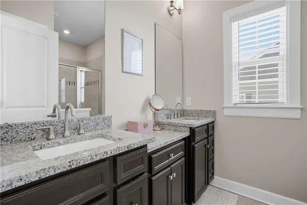 a bathroom with a granite countertop sink a mirror and a window