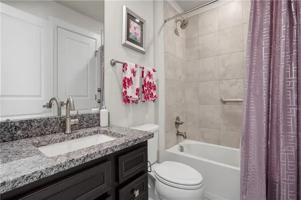 a bathroom with a granite countertop sink toilet and shower