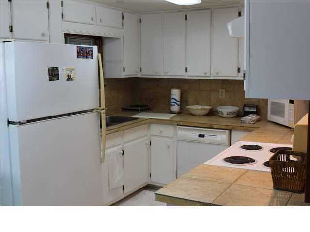 255 Garfield Street Santa Rosa Beach, FL 32459 - Photo 18 of 26 a kitchen with kitchen island a sink a stove a refrigerator and cabinets