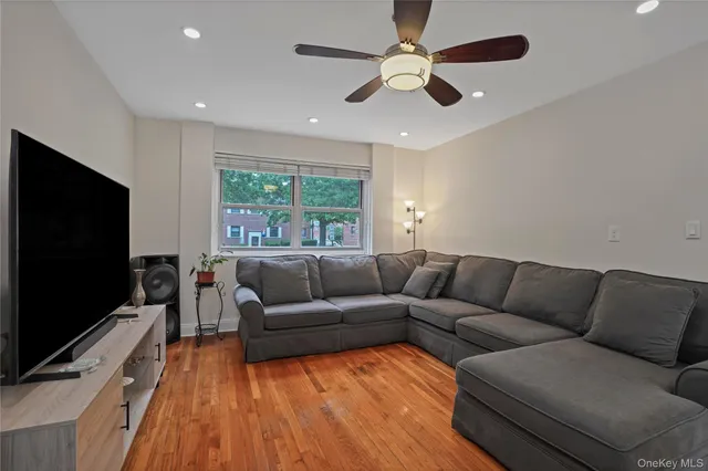 a living room with furniture flat screen tv and a large window