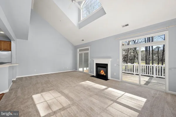 a view of an empty room with a fireplace and a window