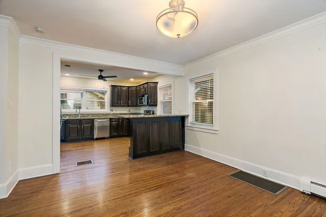 a kitchen with stainless steel appliances granite countertop a sink cabinets and wooden floor