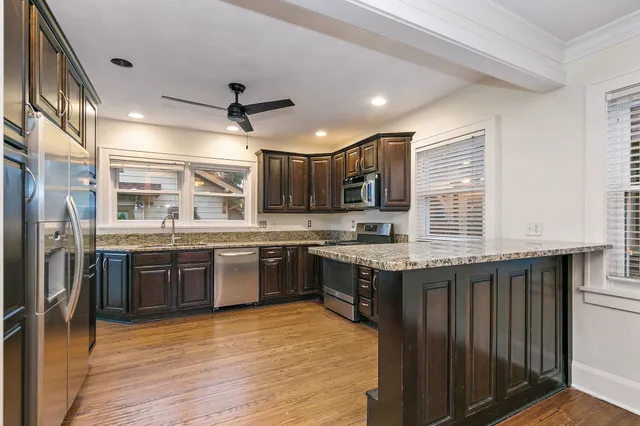 a open kitchen with stainless steel appliances granite countertop a stove and a refrigerator