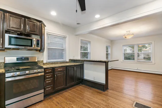 a kitchen with stainless steel appliances granite countertop a stove a sink and a microwave