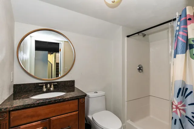 a bathroom with a toilet a sink and a mirror