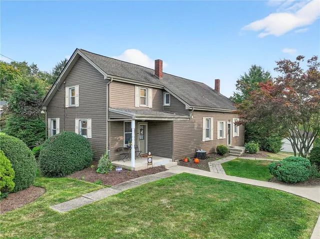 a front view of a house with a yard and outdoor seating