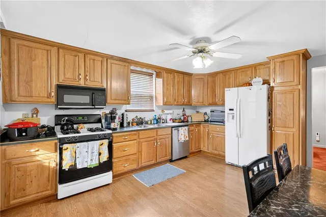 a kitchen with stainless steel appliances granite countertop a stove a sink dishwasher and a refrigerator