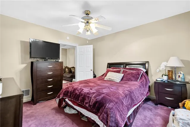 a bedroom with a bed and a flat tv screen on dresser