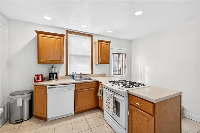 a kitchen that has a sink a stove counter top space and cabinets