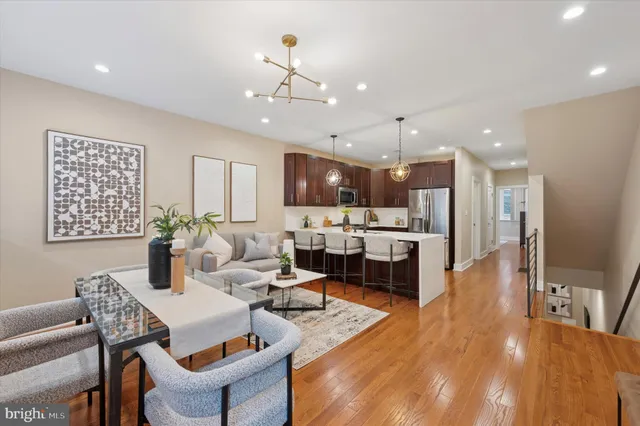 a living room with stainless steel appliances kitchen island granite countertop furniture and a dining table