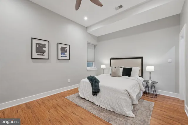 a bedroom with a bed and wooden floor