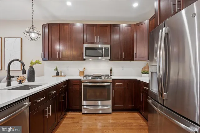 a kitchen with kitchen island granite countertop stainless steel appliances and wooden cabinets