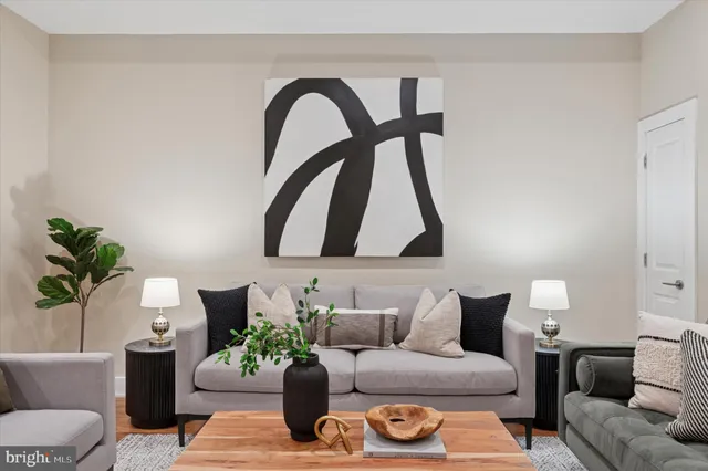 a living room with furniture flowerpot and wooden floor