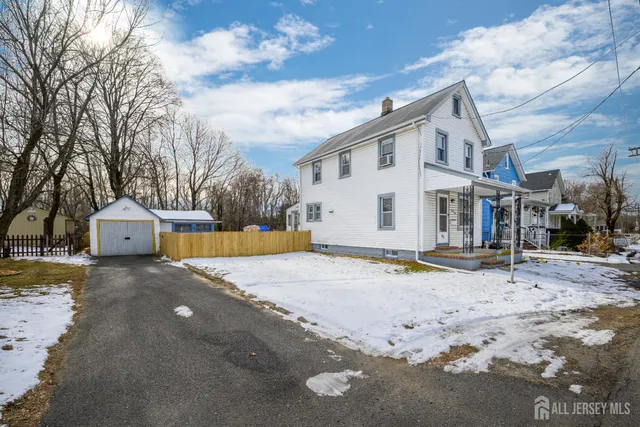 a view of a white house with a yard and covered with snow in front of it
