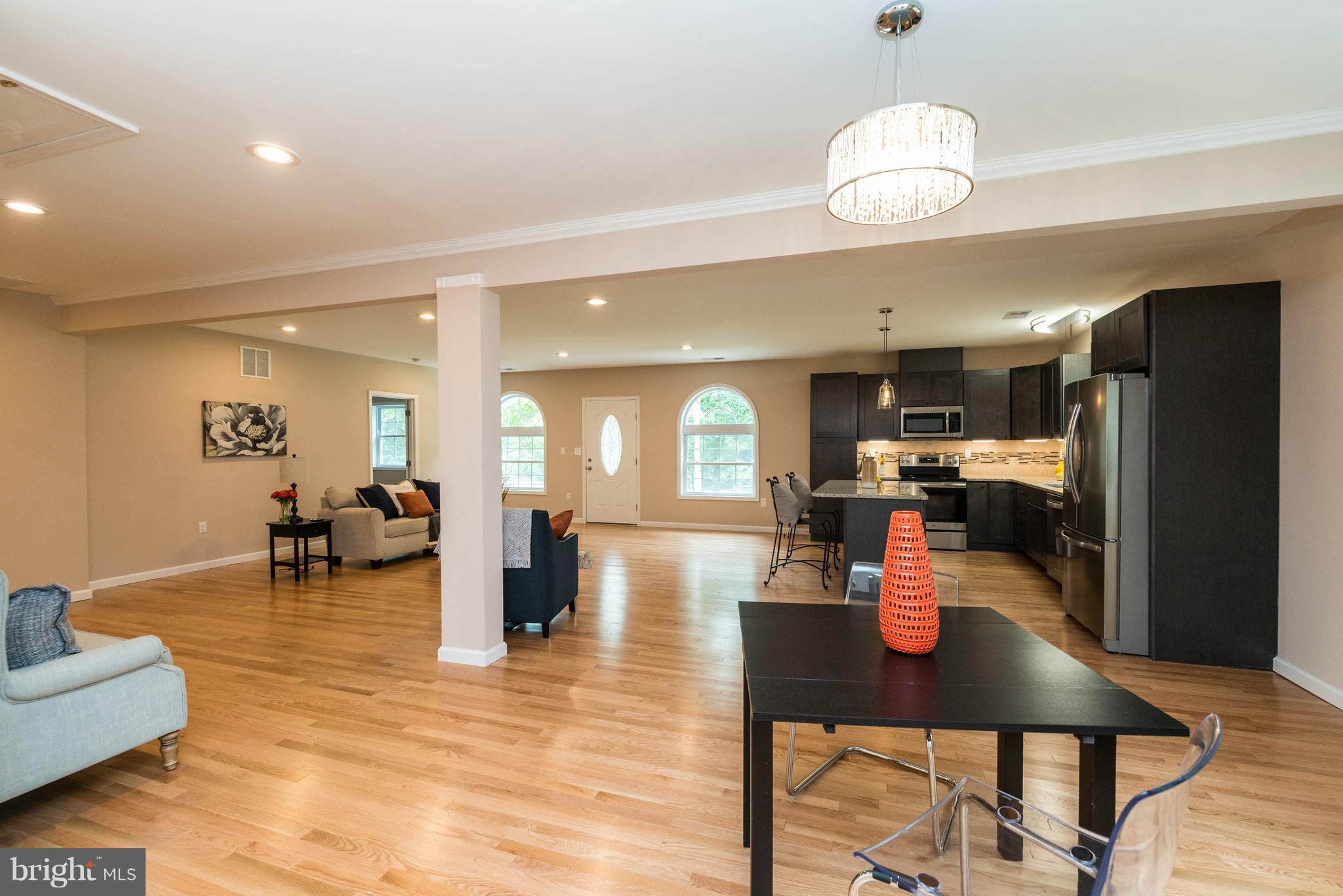 8220 Mission Road Jessup, MD 20794 - Photo 21 of 28 a living room with furniture kitchen view and a wooden floor