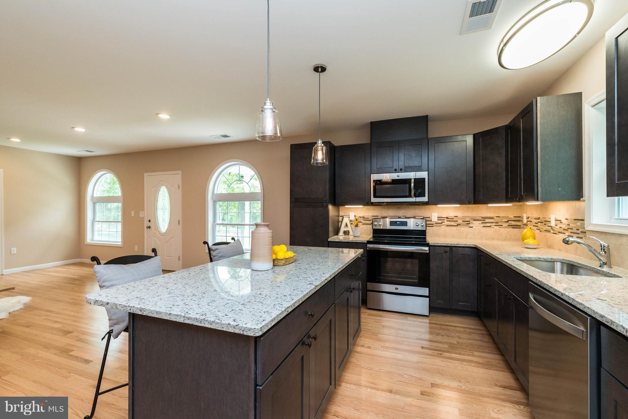 8220 Mission Road Jessup, MD 20794 - Photo 26 of 28 a kitchen with granite countertop stainless steel appliances a stove cabinets a sink and a stove