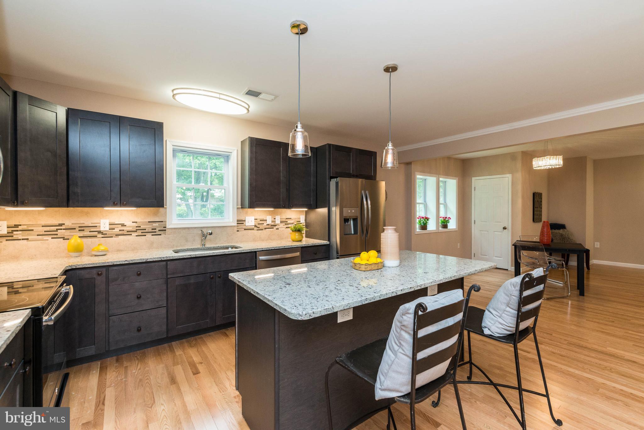 8220 Mission Road Jessup, MD 20794 - Photo 27 of 28 a kitchen with granite countertop kitchen island a table and chairs in it