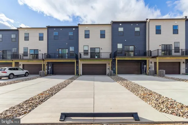 a kitchen with stainless steel appliances kitchen island granite countertop a refrigerator dining table and chairs