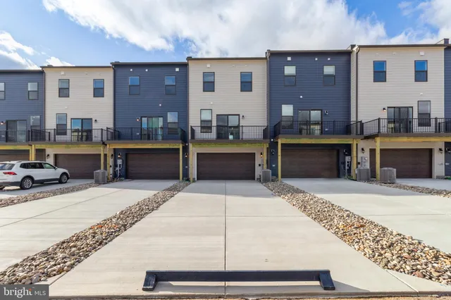 a kitchen with stainless steel appliances kitchen island granite countertop a refrigerator dining table and chairs