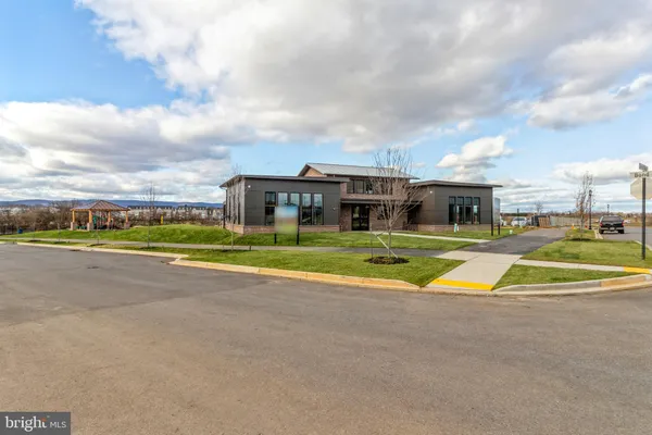 a view of swimming pool with outdoor seating and trees in the background