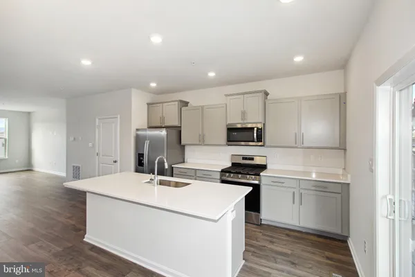 a kitchen with kitchen island a sink stainless steel appliances and cabinets