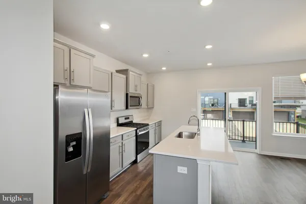a kitchen with stainless steel appliances granite countertop a refrigerator a stove and a sink