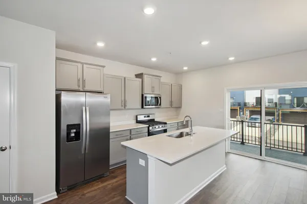 a kitchen with a refrigerator a sink and a stove top oven