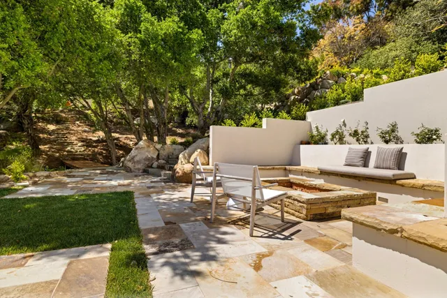a view of a patio with table and chairs plants and trees