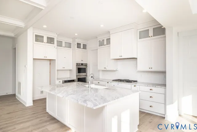 a kitchen with granite countertop a sink a counter top space and cabinets