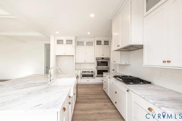 a kitchen with stainless steel appliances kitchen island granite countertop a sink stove and cabinets