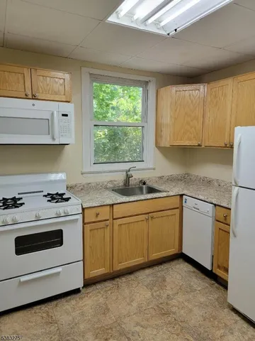 a kitchen with granite countertop cabinets stainless steel appliances and a sink