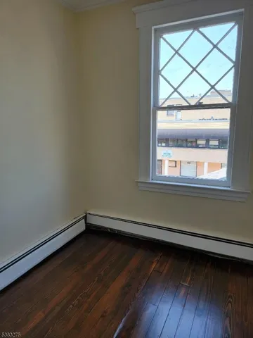 a small space with wooden floor and a window