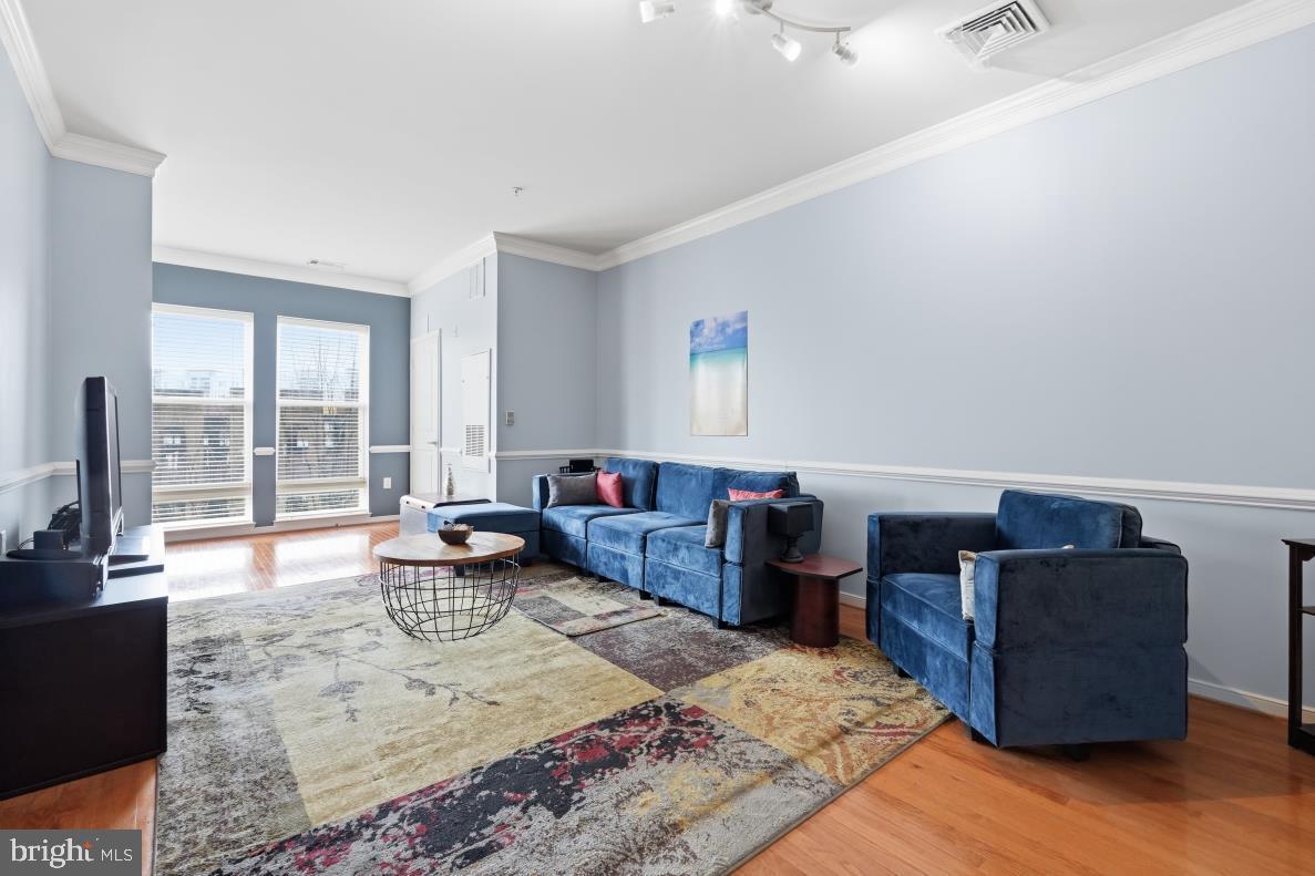8045 Newell Street, Unit 423 Silver Spring, MD 20910 - Photo 5 of 26 a living room with furniture window and wooden floor