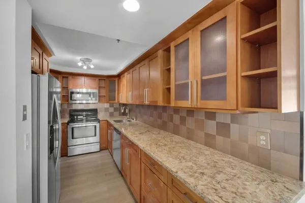 a kitchen with stainless steel appliances granite countertop a refrigerator and a sink