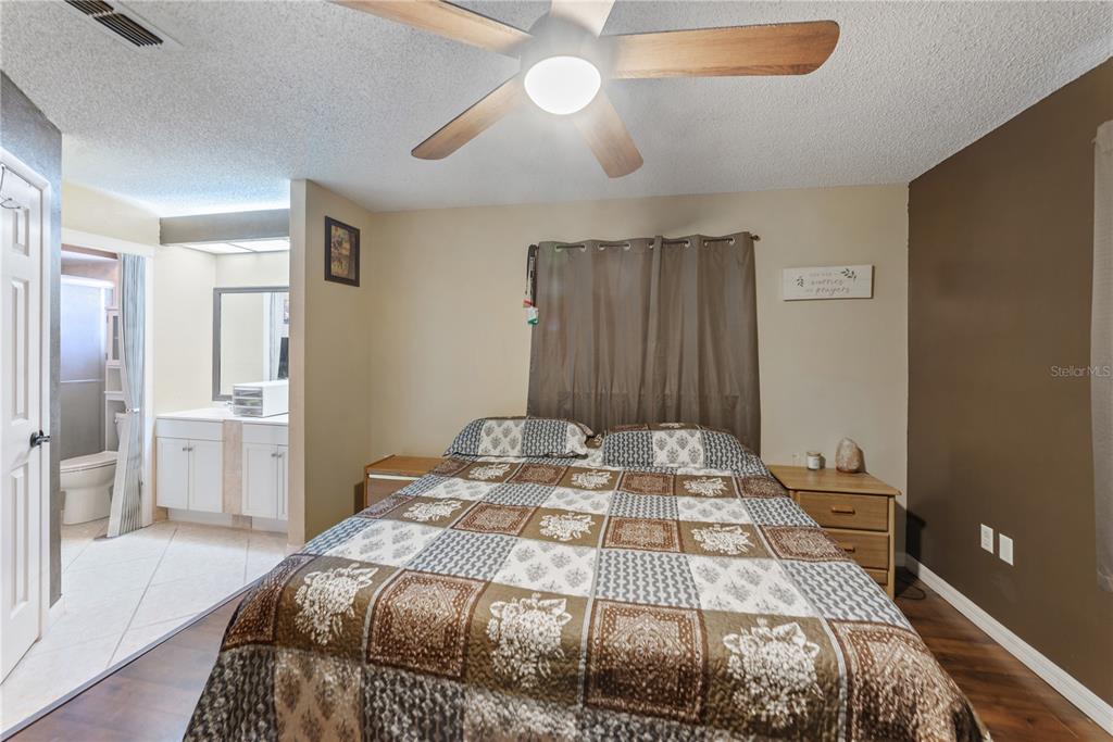 8715 Huntsman Lane Port Richey, FL 34668 - Photo 26 of 54 a bedroom with a bed and a chandelier