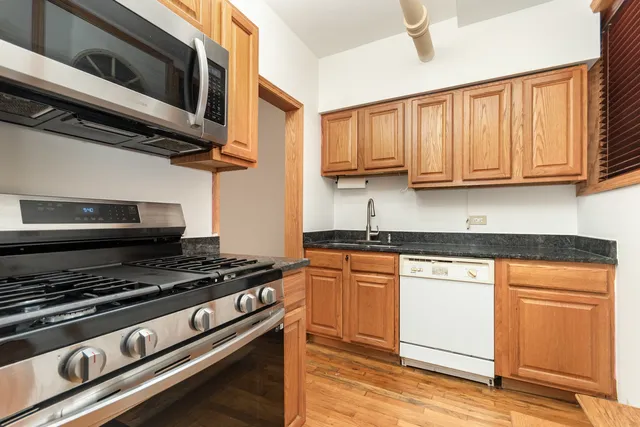 a kitchen with stainless steel appliances granite countertop a stove and a microwave
