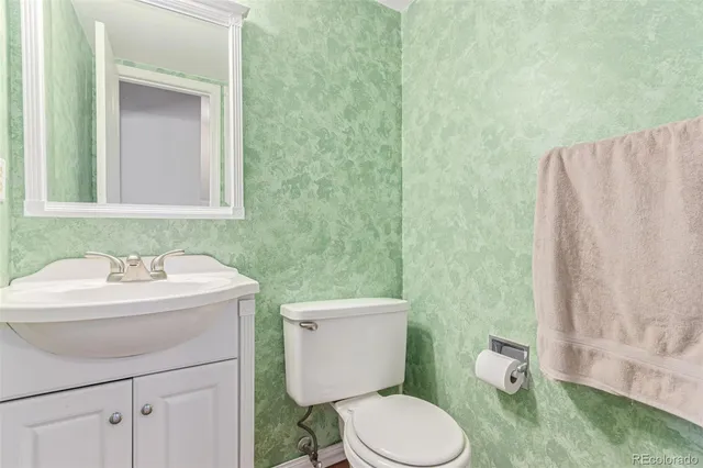 a bathroom with a sink a toilet and a mirror