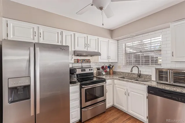 a kitchen with cabinets stainless steel appliances a sink and a window
