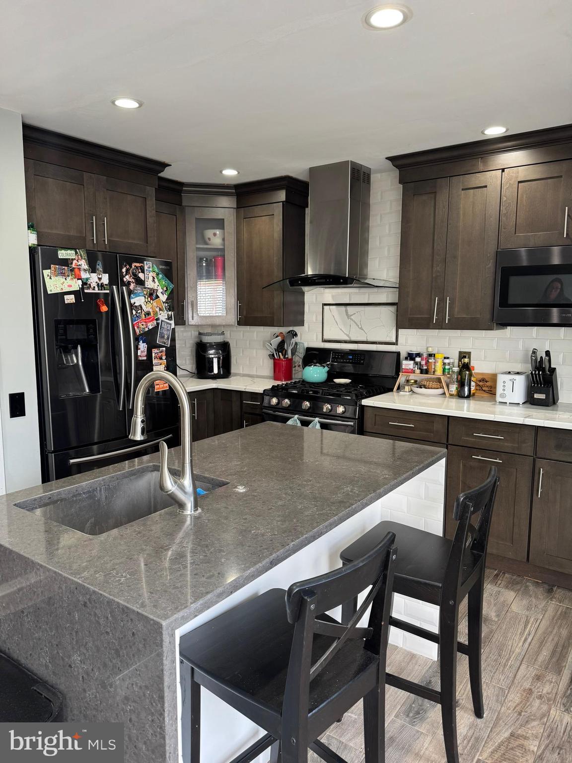 20691 Southwind Terrace Ashburn, VA 20147 - Photo 4 of 16 a kitchen with stainless steel appliances granite countertop a stove top oven a sink a dining table and chairs