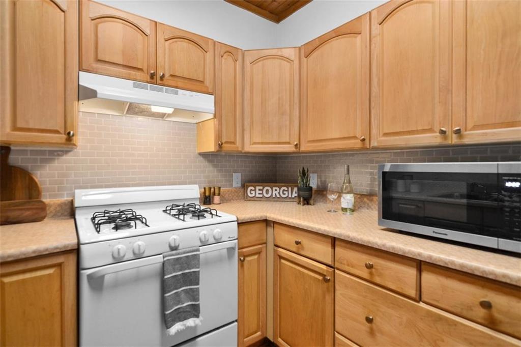 223 Mango Circle Ellijay, GA 30540 - Photo 11 of 43 a kitchen with granite countertop a sink a stove and cabinets