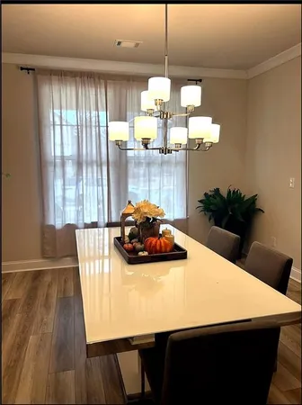 a view of a dining room with furniture a chandelier and wooden floor