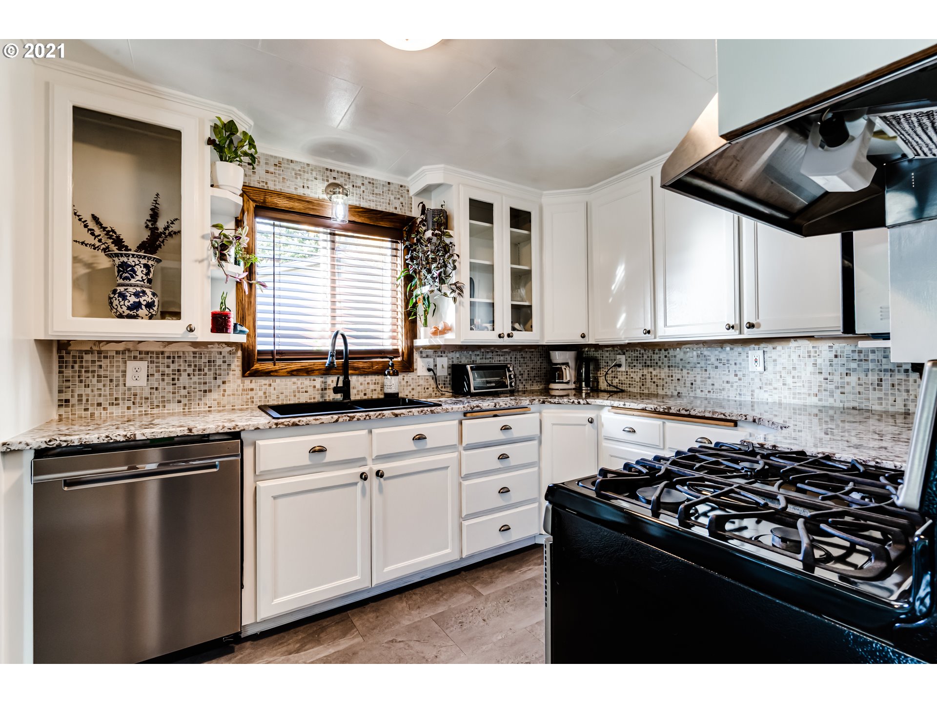 1327 E Street Springfield, OR 97477 - Photo 8 of 32 a kitchen with granite countertop a sink a stove and cabinets