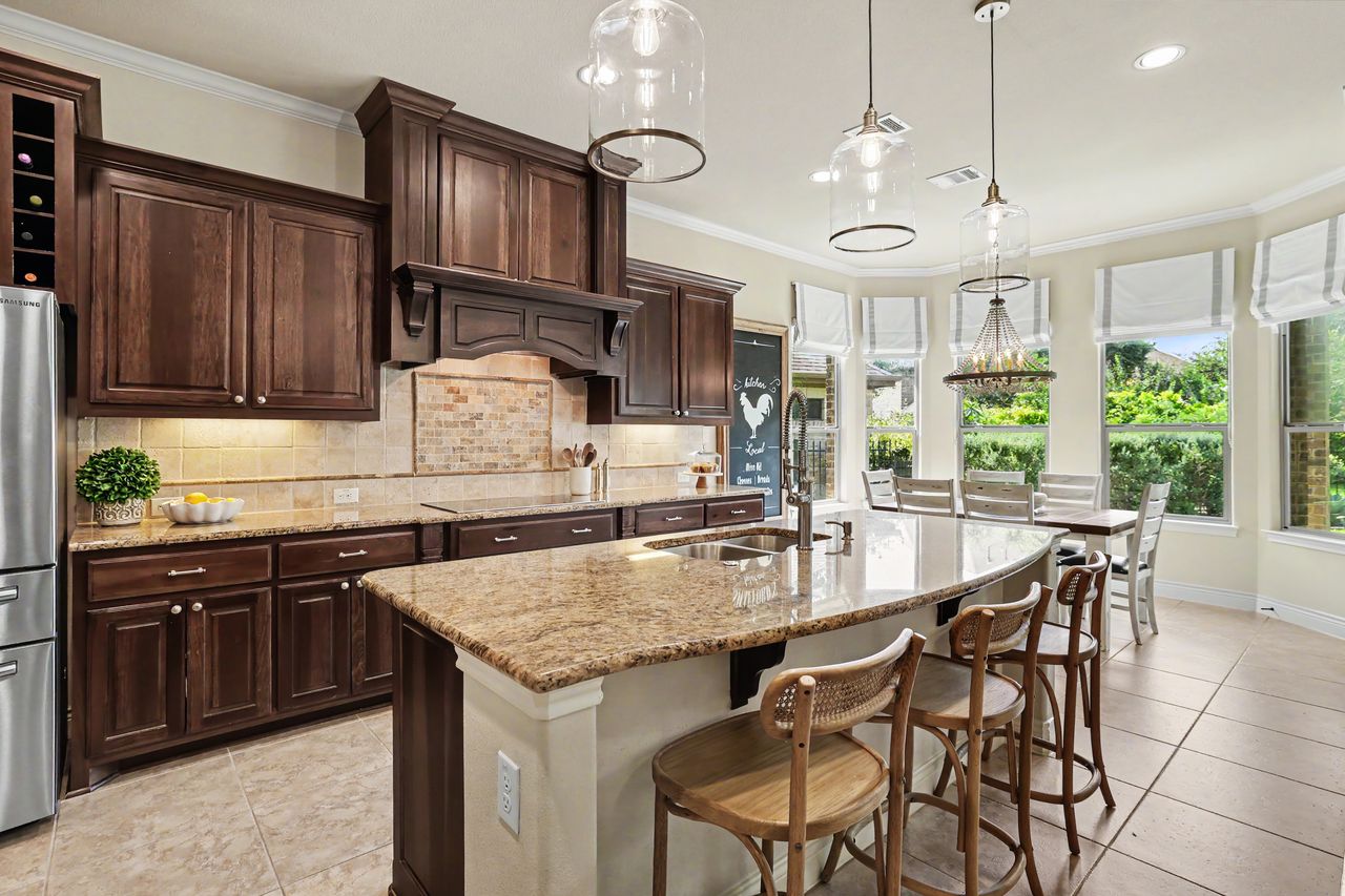 809 Prairie Dunes Drive Georgetown, TX 78628 - Photo 13 of 40 A well-appointed kitchen features rich cabinetry, granite countertops, and a charming breakfast nook with abundant natural light.