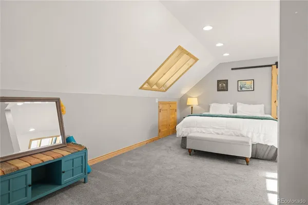 a bedroom with a bed and a mirror