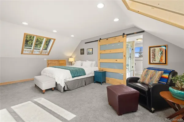 a bedroom with furniture and a large window