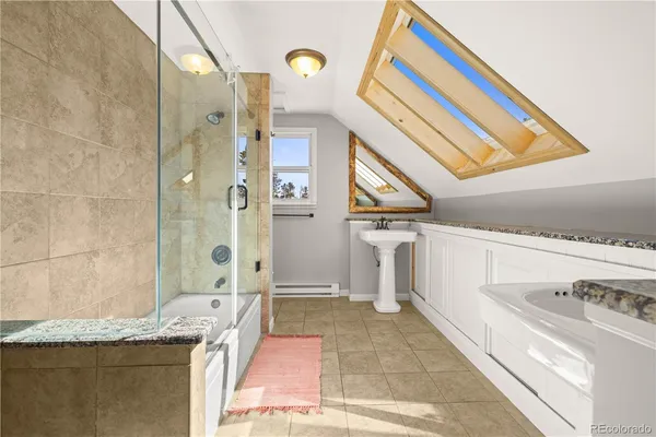 a bathroom with a granite countertop sink and washing machine