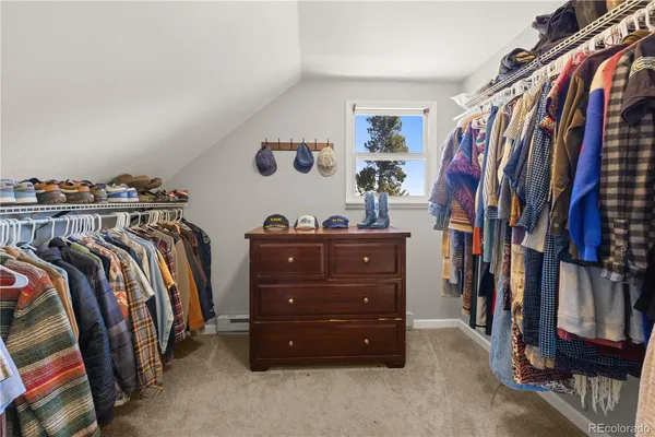 a view of walk in closet with clothes and shoes