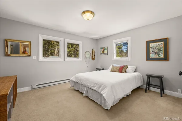 a bedroom with a bed and painting on the wall